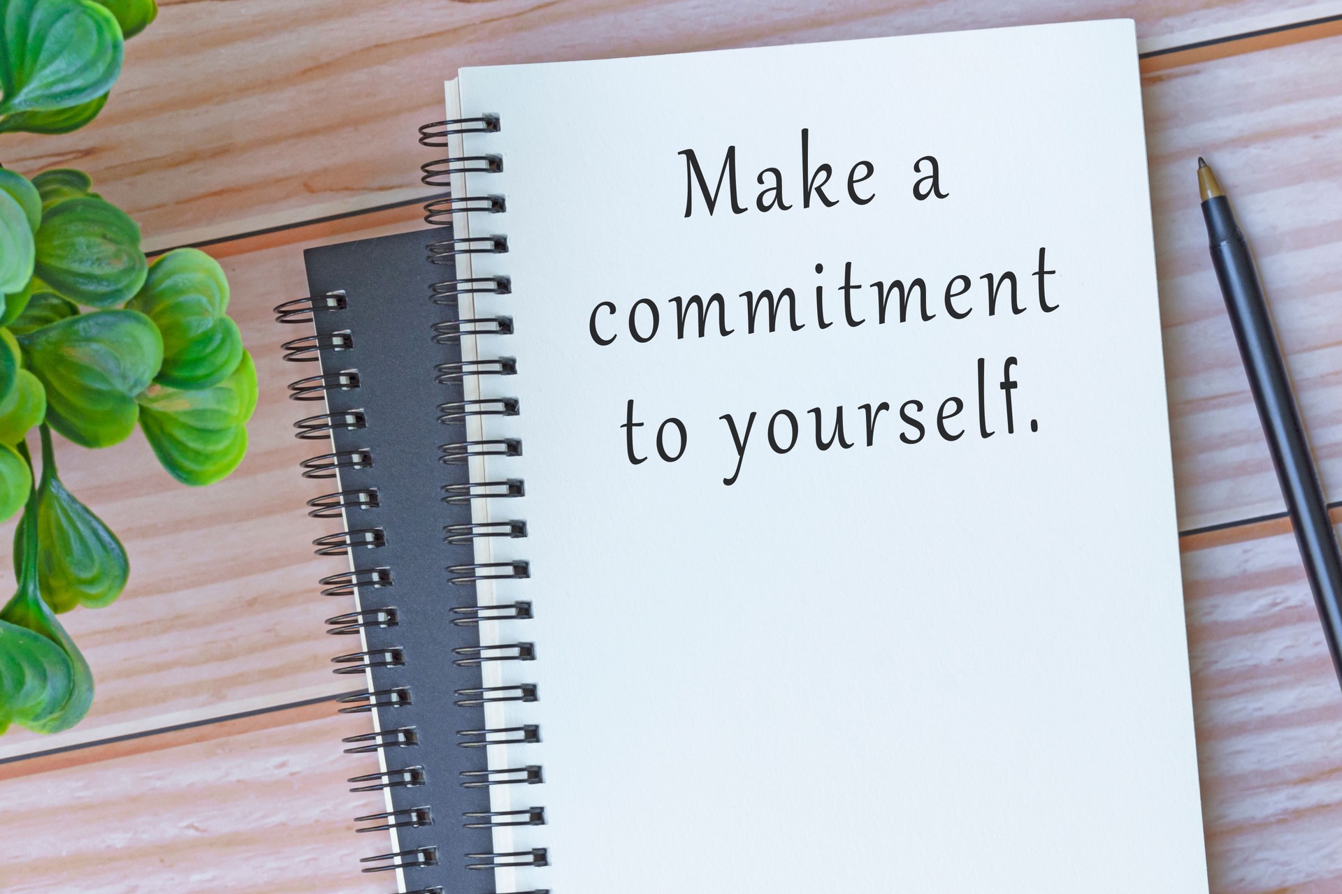 Motivational and inspirational quote on note book on wooden desk .